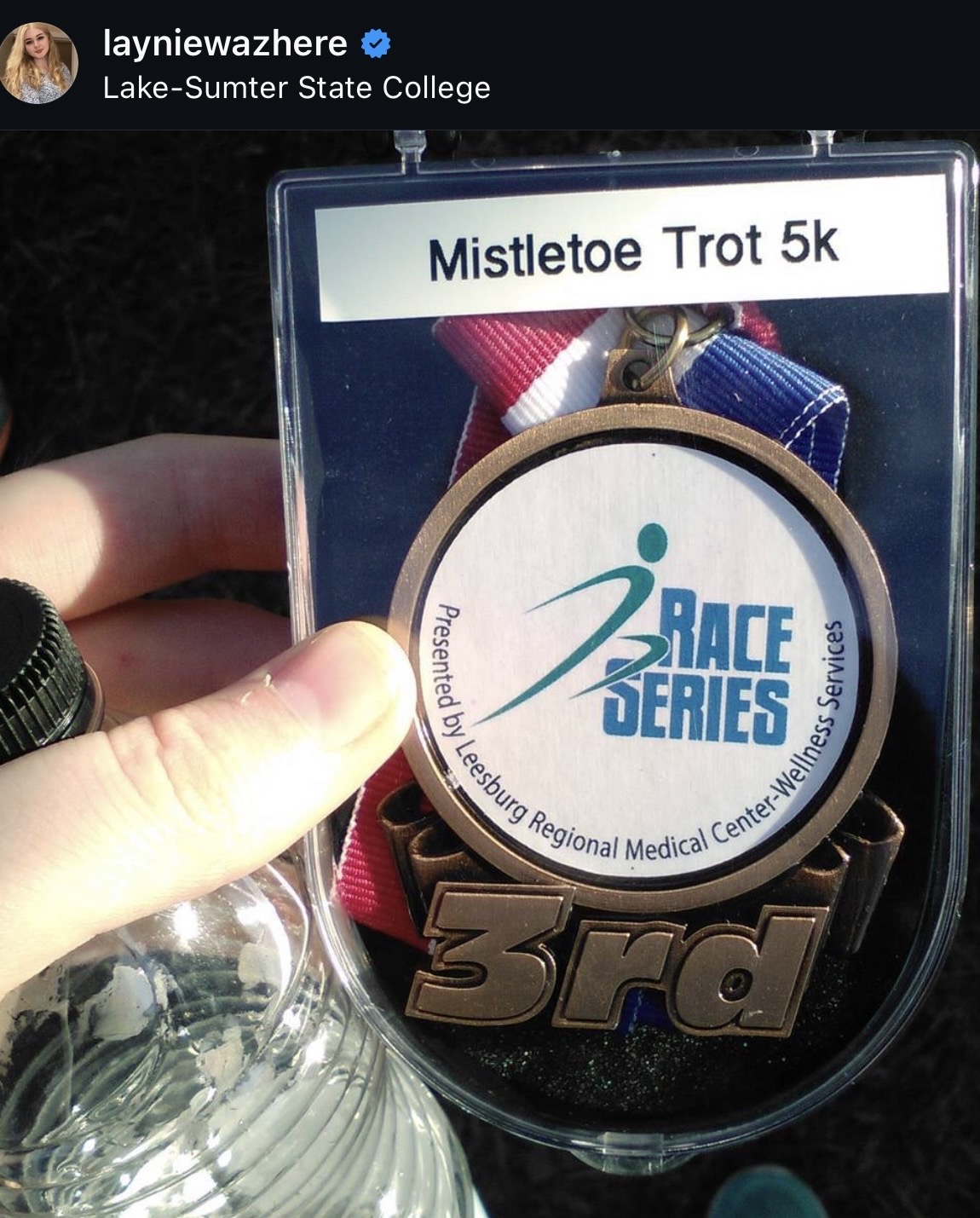 Elayne Mitchell holding her third-place medal from the Mistletoe Trot 5K